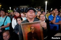 A man watch the ceremony of canonization of the late Archbishop of San Salvador Oscar Arnulfo Romero at the Gerardo Barrios Square in San Salvador, El Salvador, Oct. 14, 2018.