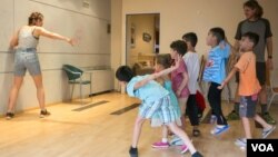 Children play with one of the volunteers in the hotel. About 180 children live here. (J. Owens/VOA)