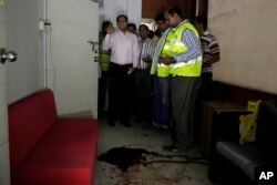 FILE - Bangladeshi security officers inspect the blood-stained site where publisher Ahmed Rahim Tutul and two writers were shot and stabbed by assailants in the office of the Shudhdhoswar publishing house, in Dhaka, Bangladesh, Oct. 31, 2015.