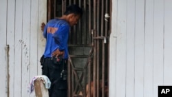 Penjaga keamanan berbicara pada tahanan di dalam sel. Para tahanan ini adalah budak-budak yang berisiko kabur dan hanya diberi sedikit makanan. (AP/Dita Alangkara)