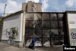 A resident looks at a burnt electrical substation after a massive blackout in Caracas, Venezuela, March 11, 2019.