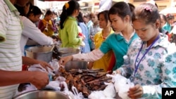 កម្មករ​រោងចក្រ​កម្ពុជាទិញ​ម្ហូប​ដេល​មាន​តម្លៃ​ថោក​សម្រាប់​អាហារ​ថ្ងៃ​ត្រង់​នៅ​មុខ​រោងចក្រ​នៅ​ទីក្រុង​ភ្នំពេញ កាល​ពី​ថ្ងៃ​ព្រហស្បតិ៍ ទី១០ ខែ​មីនា ឆ្នាំ២០១១។