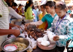កម្មករ​រោងចក្រ​កម្ពុជាទិញ​ម្ហូប​ដេល​មាន​តម្លៃ​ថោក​សម្រាប់​អាហារ​ថ្ងៃ​ត្រង់​នៅ​មុខ​រោងចក្រ​នៅ​ទីក្រុង​ភ្នំពេញ កាល​ពី​ថ្ងៃ​ព្រហស្បតិ៍ ទី១០ ខែ​មីនា ឆ្នាំ២០១១។