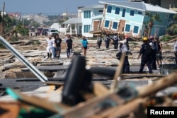 First responders and residents walk along a main street following Hurricane Michael in Mexico Beach, Florida, Oct. 11, 2018.