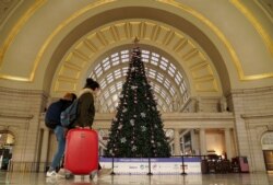 Holiday week train passengers walk by a Christmas tree at Union Station, during the coronavirus disease (COVID-19) pandemic, in Washington, U.S., December 23, 2020.