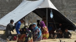 Afghan refugees sit around a makeshift tent shelter on the outskirts of Quetta, Pakistan on Sept. 6, 2021.