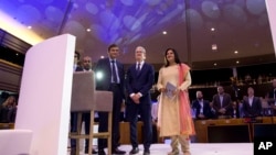 \European Data Protection Supervisor Giovanni Buttarelli, left, poses with Apple CEO Tim Cook, center, during a data privacy conference at the European Parliament in Brussels, Wednesday, Oct. 24, 2018. (AP Photo/Virginia Mayo)