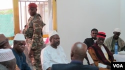 Guinea Prime Minister Mohamed Said Fofana, in white, discusses Ebola with community leaders in a village near his hometown of Forecariah on Sept. 27, 2014. (Carol Guensburg/VOA)