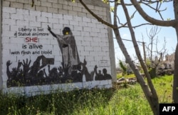 A mural painting of a protesting Alaa Salah is seen on the wall of a farmhouse building in the rebel-held Syrian town of Kafranbel in the northwestern Idlib province, April 12, 2019.