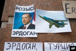 FILE - Posters showing a portrait of Turkish President Recep Tayyip Erdogan and reading "Wanted, Erdogan, Turkey," are left after a protest against Ankara's downing of a Russain warplane, at the Turkish Embassy in Moscow, Nov. 25, 2015. Bilateral relations fell to a low point following the incident but have been gradually improving.
