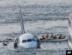 FILE - In this Jan. 15, 2009 file photo, passengers in an inflatable raft move away from an Airbus 320 US Airways aircraft that has gone down in the Hudson River in New York.