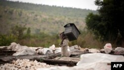 Un homme du village d'Ibi étale des tubercules du manioc sur des plates-formes de séchage au plateau de Bateke, à environ 100 kilomètres de Kinshasa, le 11 octobre 2011.