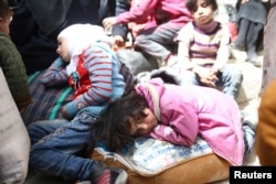 A girl looks at the camera during evacuations from eastern Ghouta, near Damascus, Syria.