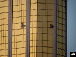 FILE - In this Oct. 2, 2017 file photo, drapes billow out of broken windows at the Mandalay Bay resort and casino on the Las Vegas Strip, following a mass shooting at a music festival in Las Vegas.