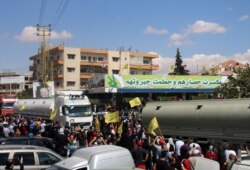 Orang-orang mengibarkan bendera gerakan Syiah Lebanon Hizbullah, saat menyambut kedatangan tanker yang membawa bahan bakar Iran dari Suriah, di kota Baalbeck, lembah Bekaa Lebanon, 16 September 2021.