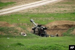 FILE - Armenian soldiers aim a howitzer, April 3, 2016, in the village of Mardakert, in the separatist region of Nagorno-Karabakh.