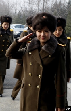 Members of the Moranbong Band and the State Merited Chorus of North Korea walk to get on a train at the station in Pyongyang, North Korea, Wednesday, Dec. 9, 2015.