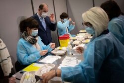 French Prime minister Jean Castex (C) talks to nurses during a visit at a Covid-19 vaccination center in Nantes, western France, Jan. 21, 2022 .