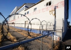 FILE - An abandoned building sits on the route for California's planned high-speed rail line in Fresno, Calif., July 17, 2013. Work is set to start on the first 30 mile segment of track in this city of 500,000 people with soaring unemployment and a withering downtown core. The rail line was sold to voters five years ago as a way to create jobs, cut pollution and ease gridlock, but many residents have since soured on the $68 billion plan.