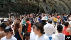 Numerous tourists walk along the Maya Bay, Phi Phi Leh island in Krabi province, Thailand, Thursday, May 31, 2018. (AP Photo/Sakchai Lalit)