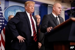 President Donald Trump, left, listens as Brandon Judd, president of the National Border Patrol Council, talks about border security, Jan. 3, 2019, after making a surprise visit to the press briefing room of the White House.