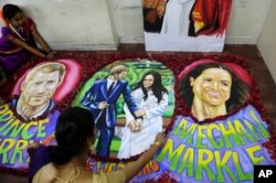 Students of an art school decorate paintings of Britain's Prince Harry and Meghan Markle with flower petals in Mumbai, India, May 18, 2018. The royal wedding is set for May 19 at England's Windsor Castle.