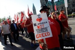 Members of Canada's Unifor union march past Parliament Hill during a rally ahead of the third round of NAFTA talks involving the United States, Mexico and Canada in Ottawa, Ontario, Sept. 22, 2017.
