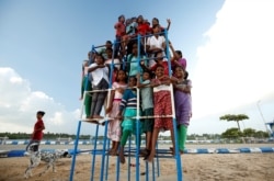 Children staying in the care home set up by Karibeeran Paramesvaran and his wife Choodamani pose in a park along a beach in Nagapattinam district in the southern state of Tamil Nadu, India.