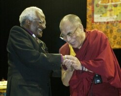 FILE - The Dalai Lama (R) greets South African Archbishop Desmond Tutu in Vancouver, British Columbia, Apr. 18, 2004.