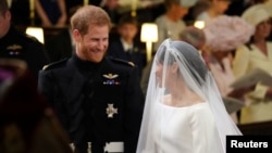 Prince Harry looks at his bride, Meghan Markle, as she arrives accompanied by the Prince of Wales in St George's Chapel at Windsor Castle for their wedding in Windsor, Britain, May 19, 2018.