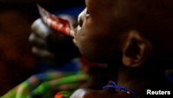 FILE - A mother feeds her child with a peanut-based paste for treatment of severe acute malnutrition in a UNICEF supported hospital in Juba, South Sudan, Jan. 25, 2017.