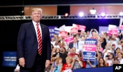 FILE - President Donald Trump stands before speaking at a rally at the Phoenix Convention Center, Aug. 22, 2017, in Phoenix.