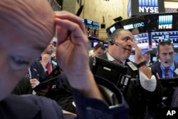 FILE - Anthony Riccio, center, works with fellow traders on the floor of the New York Stock Exchange, Nov. 9, 2016. Investors have been yanking money out of bonds around the world, sending prices tumbling and wiping out several months of gains in widely held U.S. government debt since the election.