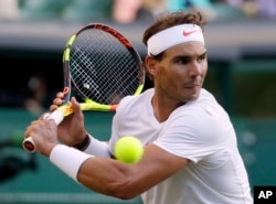 Petenis Spanyol Rafael Nadal memukul bola kembali ke arah petenis Argentina, Juan Martin Del Potro dalam laga perempat final tunggal putra turnamen tenis Wimbledon di London, Rabu, 11 Juli 2018. (AP Photo/Kirsty Wigglesworth)