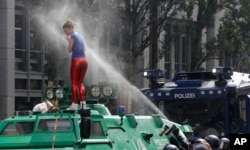 Seorang perempuan terkena semprotan merica polisi saat dia menaiki mobil baja milik polisi pada hari pertama pelaksanaan KTT G-20 di Hamburg, utara Jerman, 7 Juli 2017.