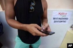 A man stands at a Wi-Fi hot spot in the aftermath of Hurricane Maria with many cellphone towers down in San Juan, Puerto Rico, Sept. 24, 2017.