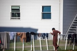 FILE - An Afghan refugee stands outside temporary housing at the Fort McCoy U.S. Army base in Fort McCoy, Wis., Sept. 30, 2021.