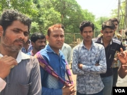 Despondent laborers wait for work at a busy junction in Gurugram near New Delhi. Demand for labor has dipped as work at many construction sites slows down. (A. Pasricha/VOA)