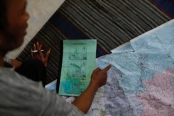 Cukup Rudiyanto menunjukkan peta kawasan di mana mereka menanam pohon bakau di Desa Pabeanilir, Kabupaten Indramayu, Jawa Barat, 14 Maret 2021. (Foto: Willy Kurniawan/Reuters)