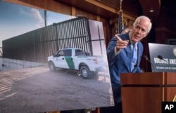 Senate Majority Whip John Cornyn of Texas points to a poster as he talks to reporters about border security on Capitol Hill, Washington, Aug. 3, 2017.