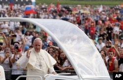 Pope Francis followed by a security guard arrives to celebrate a mass at conclusion of the World Youth Day inKrakow, Poland, Sunday, July 31, 2016.