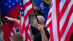 FILE - A member of a white supremacy group gives a fascist salute during a gathering in West Allis, Wisconsin, Sept. 3, 2011.