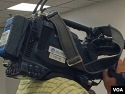 在六四纪念活动现场“采访”的新华社记者。（美国之音安华拍摄）