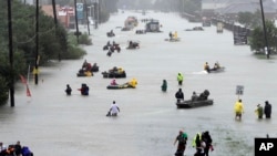 Rescue boats fill a flooded street as flood victims are evacuated during Tropical Storm Harvey, Aug. 28, 2017, in Houston.
