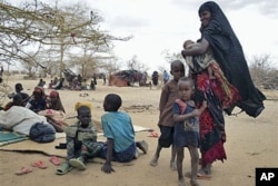 FILE - Refugees rest outside in an open area as there is lack of tents at the Dollo Ado refugee camp, Ethiopia, July 7, 2011.