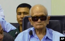 In this photo released by the Extraordinary Chambers in the Courts of Cambodia, Nuon Chea, center, who was the Khmer Rouge's chief ideologist and No. 2 leader, sits in the court room during a hearing at the U.N.-backed war crimes tribunal, in Phnom Penh,