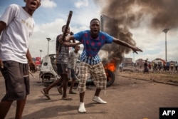 Demonstrators gather in front of a burning car during an opposition rally in Kinshasa, DRC, Sept. 19, 2016.