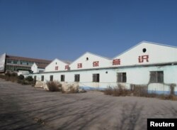 The abandoned warehouse of a shuttered ceramics factory in Zibo, marked with the slogan "Increase environmental awareness," Shandong province, China Nov. 23, 2017.