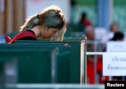 A woman casts her early vote for the upcoming Thai election at a polling station in Bangkok, Thailand, March 17, 2019.