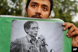 A student holds a portrait of a University Professor A.F.M. Rezaul Karim Siddique during a protest against the killing in Dhaka, Bangladesh, April 29, 2016.